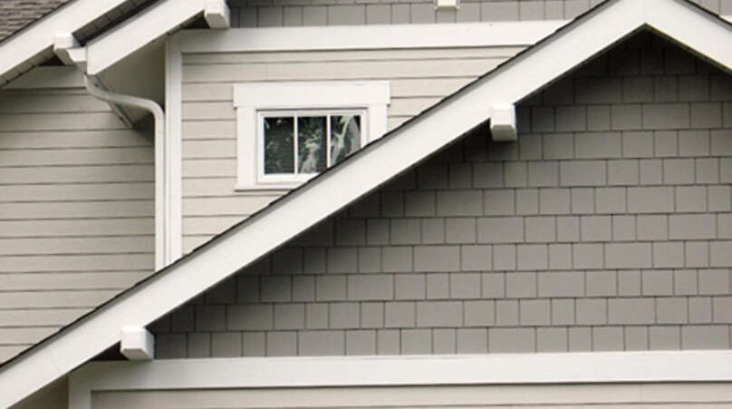 A close up beige and gray James Hardie siding to illustrate the difference between James Hardie Siding vs Vinyl